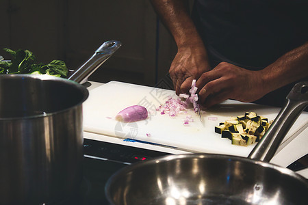 在专业的厨房里 把洋葱 切在砍板上 用手贴近人手图片
