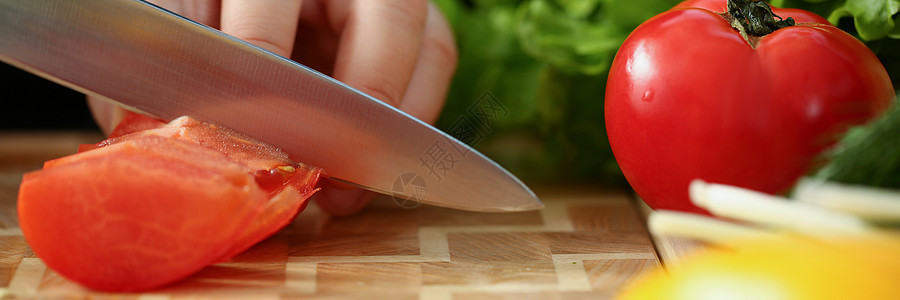 一个男人用刀割红番茄的肉图片