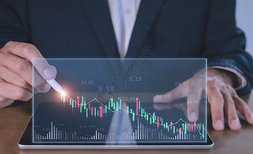 商务人士在平板电脑屏幕上撰写贸易股票市场分析图 商务人士手绘图图表股票的增长 手人用笔绘制目标成功的股票图表点商业经济数据报告外图片
