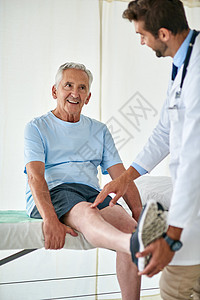 他和友善的医生一起做检查总是很有趣 一个快乐的老人和医生一起参加膝盖检查的镜头图片