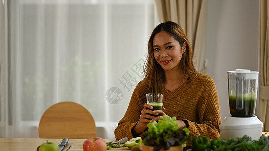 有吸引力的年轻亚洲女人 喝绿色脱毒蔬菜沙丁鱼做早餐图片