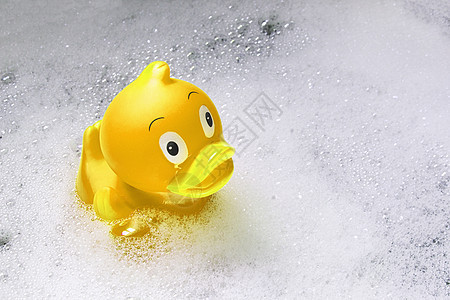 浴缸肥皂泡中黄色玩具橡胶鸭图片