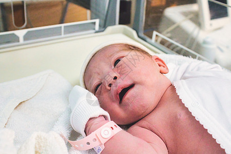 刚出生在产科病房医院的新生儿女婴 手腕上贴着塑料标签图片