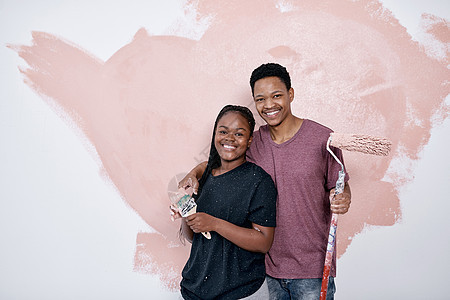 艺术是爱情的终极表达 一对年轻夫妇在墙上画粉红色图片