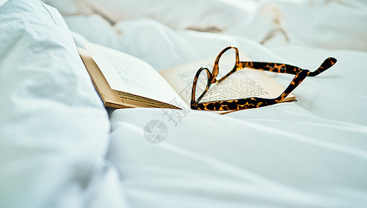 没什么比穿着好读的滑到床上更好了 书和床边一副眼镜还活生生地拍下来图片