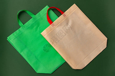 绿色背景平地上的纺织品购物袋塑料袋购物手提包棉布营销手提袋生产空白店铺生态市场图片