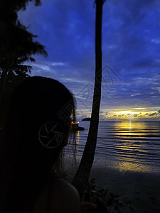 在日落时的海景与美丽的天空 海滩上的女人 在海边的年轻快乐的女人 女孩看着神奇的日出图片