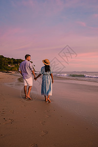 在泰国海滩观看日落的男女夫妇橙子海岸海洋季节热带男人棕榈假期夫妻蜜月图片