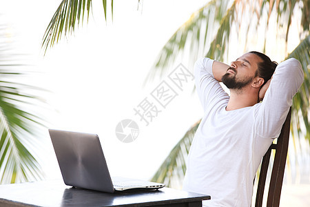 男人在海滩上放松 用笔记本电脑 自由职业者工作场所 梦想工作企业家天空人士技术男性商务成人旅行商业互联网图片