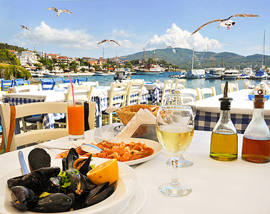 在希腊海边的希腊希腊餐馆吃海鲜晚饭 配有海鸥图片