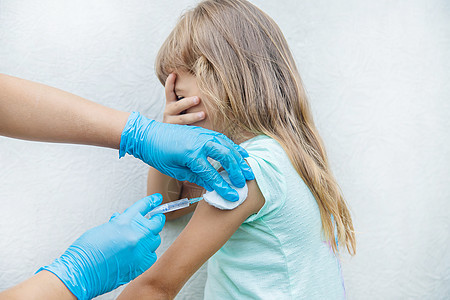 医生给孩子注射手臂 有选择的专注点流感医院女孩感染男人女士护士病人婴儿注射器图片