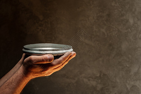 在黑暗背景 缺乏食物 饥饿概念下 男性手握空盘子用具粮食厨具服务危机饮食烹饪用餐圆形午餐图片