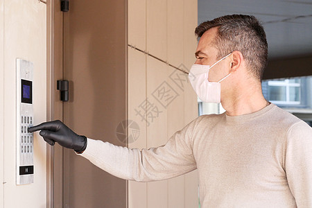 戴医疗面具的男子用蒙面膜拨打门码药品口罩安全公寓街道男性房子卫生成人感染图片
