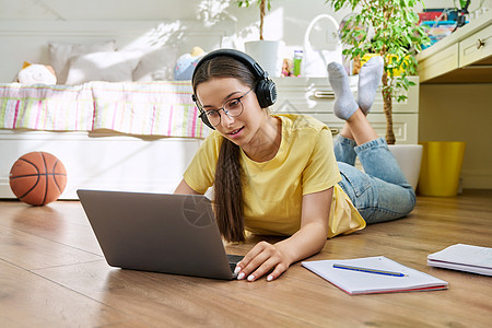 带眼镜的少女在家里使用笔记本电脑学习考试学校女孩女士青少年青春期耳机家庭作业公寓大学图片