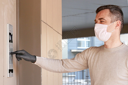 戴医疗面具的男子用蒙面膜拨打门码房子口罩安全药品男人男性公寓卫生感染成人图片