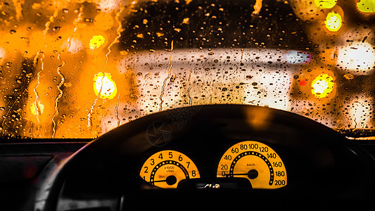 下雨时汽车内务 雨天路灯光的模糊性降低运动交通玻璃速度司机时间季节红灯运输方向盘图片