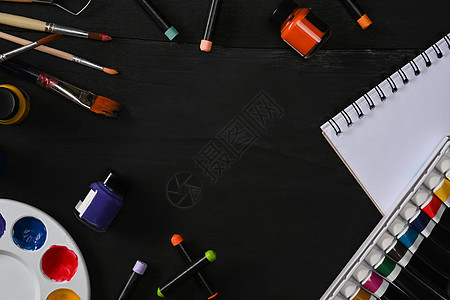 空白木桌上有速写本画笔 管漆 水彩和调色板的艺术家工作区 艺术 车间 绘画 创意概念图片