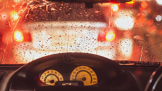 下雨时汽车内务 雨天路灯光的模糊性降低方向盘蓝色天气街道运输背景雨滴城市速度运动图片