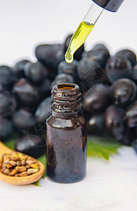 葡萄籽油在一个小瓶子里 有选择性的焦点蔬菜芳香木板身体草本植物头发种子药品治疗植物图片