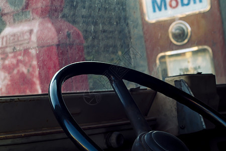 经典老爷车内部停放老式加油站 有方向盘特写镜头的一辆老汽车的内部 复古车在柔和的灯光效果 老式汽车的细节-内部汽车沙龙的复古照片图片