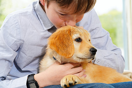 年轻男孩在家里玩小狗狗的游戏 他很聪明动物友谊猎犬婴儿男生家庭卧室苗圃幸福孩子们图片