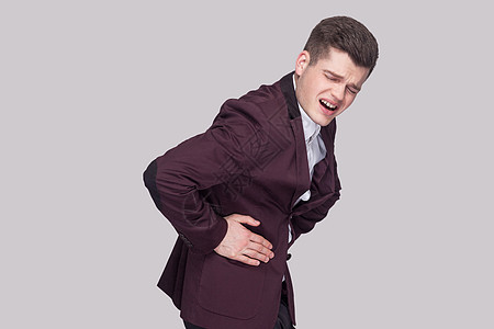 身穿灰色背景西装的情感年轻男子卫生痛苦冒号压力饮食胃炎男性商务肠胃紫色图片