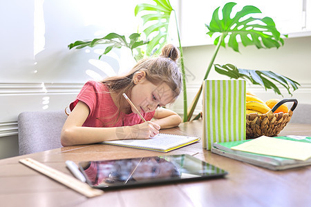 在家学习 坐在书桌上 写学校笔记本的小女孩知识微笑家庭作业瞳孔小学生教育铅笔教科书女学生工具图片