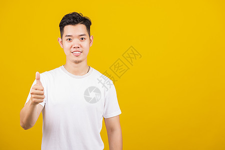 男人笑着展示正面的拇指举起手势行动手指工作室运动微笑男生男性快乐成功学生图片