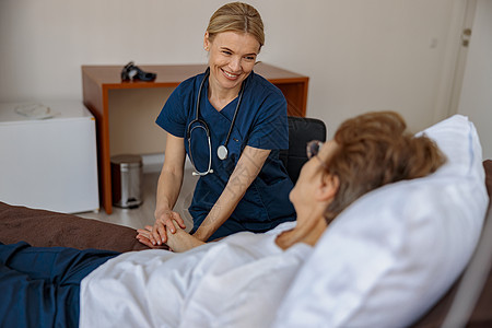医生用手扶着一名病人 帮助她坐在医院的病房里服务女性保健办公室女士药品护士快乐职业卫生图片