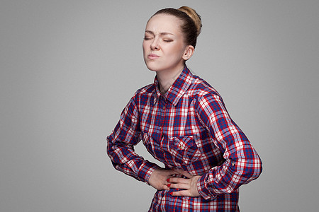 灰色背景的情感金发女孩肠胃便秘胀气腹痛痛苦保健医疗腹泻疼痛卫生图片