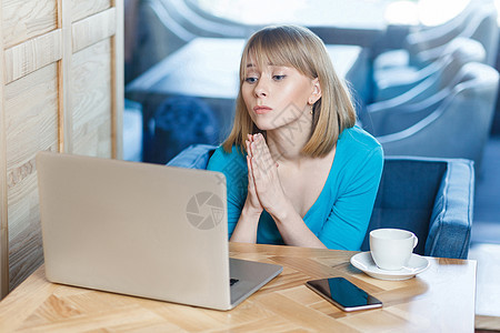 穿着蓝衬衫 坐着并从事计算机工作的情感劳动妇女失败电脑女孩女士工人互联网感激笔记本自由职业者商业图片