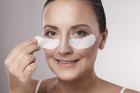 灰色背景的中年妇女的健康 美容和保健概念成人虚胖化妆品程序生活方式眼睛治疗女士润肤女性图片