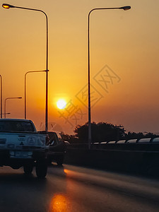 公路上的交通包 交通公路旅行概念 在有日落橙色天空的沥青高速公路上图片