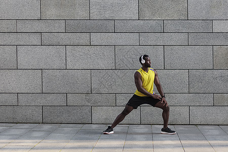 非裔美国人的慢跑运动员在早上锻炼后做伸展工作火车城市皮肤背景关节体操力量灰色保健耳机图片