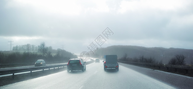 汽车  画在丹麦的一个雨天 汽车在高速公路上超车 在风景如画的寒冷多雾的冬日 机动车在危险的柏油路上行驶 恶劣天气安全驾驶背景