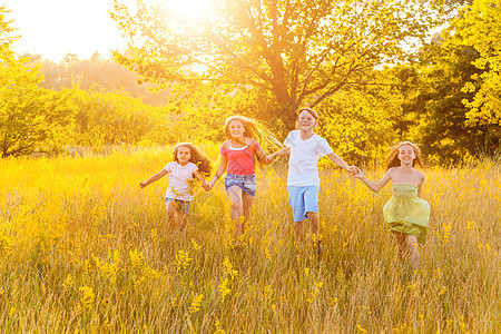 四位快乐的美丽孩子 在美丽的夏日 一起奔跑 一起玩耍喜悦跑步女性女孩场地幸福友谊男性草地太阳图片