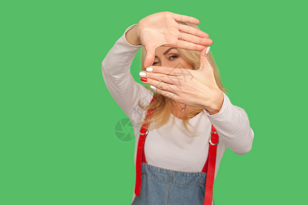 玉石拍摄图片有着绿色背景的情感金发女人的肖像手指牛仔作品背带裤想像力女性相机摄影成功手臂背景