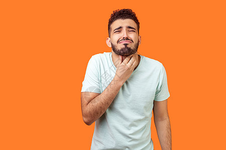 年青的长胡子男子 橙色背景流感拉丁吞咽保健男性症状男人胡须伤害脖子图片