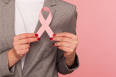 紧紧女性手握粉色丝带 乳癌警告图片