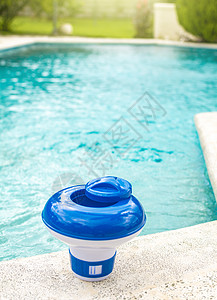游泳池边缘的氯漂浮物 用于背景为蓝色水的游泳池的氯分配器 游泳池加氯加药浮子图片