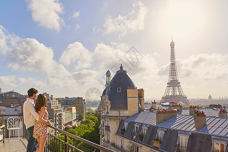 一对年轻夫妇在法国巴黎Eiffel铁塔上 俯视公寓阳台的风景时 拍到一对年轻的情侣图片