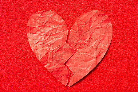 红纸心脏被红色背景撕碎的上下一拍图片