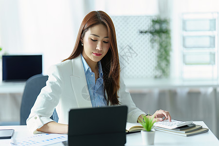 商务图使用平板电脑 预算计算器和办公室营销规划师绘制亚洲女商务人士或商业业主肖像图 )背景