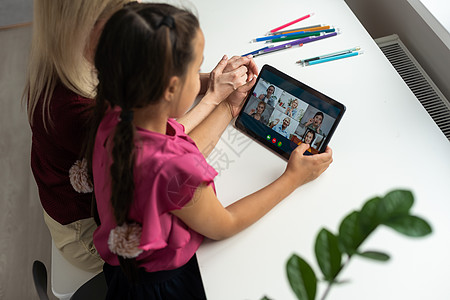 使用数字平板电脑在家网上聊天 母亲和女儿在家中用数码平板客厅学习娱乐女士教育微笑工具视频孩子妈妈图片