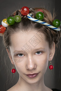 一个有趣的十几岁女孩的肖像 头上戴着甜食花圈魅力灰色女性微笑化妆品青少年背景糖果指甲女士图片