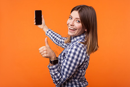 带着橙色背景的情感年轻黑发女人关系互联网手指成功视频棕色微笑因果头发衬衫图片