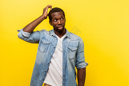 年轻的情绪男子 在黄色背景解决方案想像力衬衫男性鬼脸战略创造力男人琢磨抓挠图片