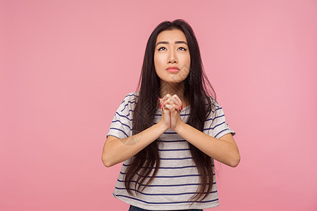 粉红色背景的亚洲年轻女性肖像祷告上帝黑发情感女士上诉失败饶恕女孩感激图片