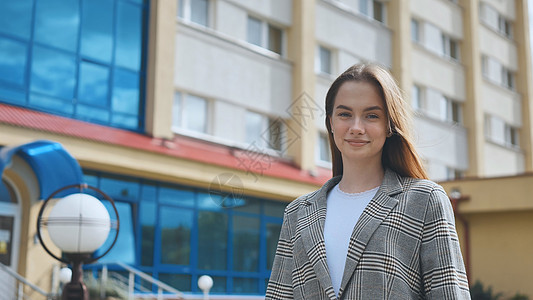 一只海雀里的年轻女学生在城里走来走去图片