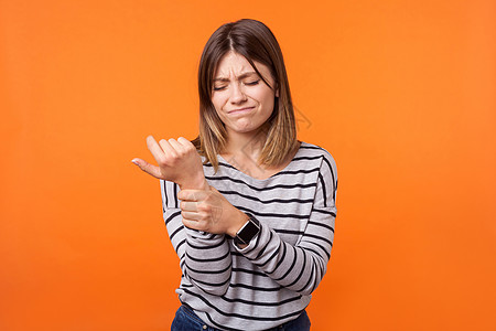 带着橙色背景的情感年轻黑发女人女士疾病头发鬼脸药品棕榈女性身体按摩因果图片